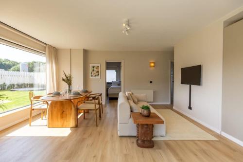 a living room with a table and a couch at Casiola - Charming Apartment with Garden & Parking in Cadzand