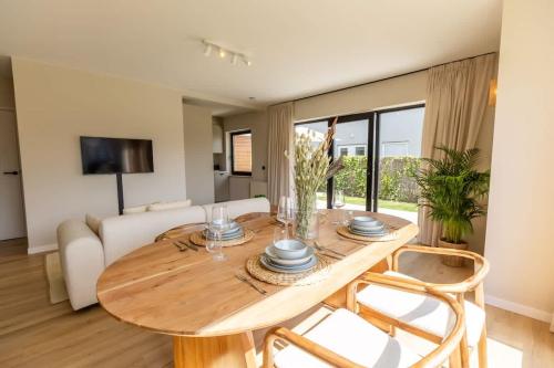 a living room with a wooden table and chairs at Casiola - Charming Apartment with Garden & Parking in Cadzand
