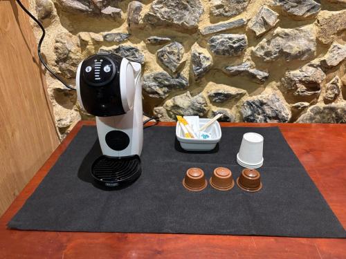 a coffee maker sitting on a table next to cupcakes at Hostal San Juan Oyarbide Tolosa in Tolosa