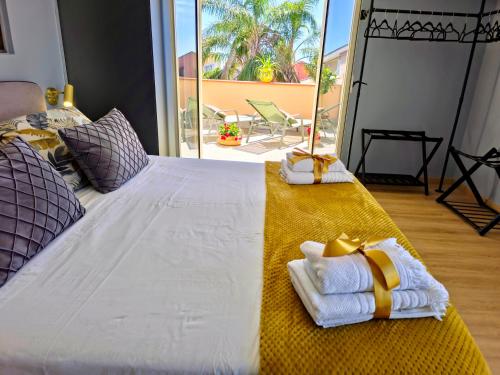 a bedroom with a large bed with towels on it at SuiteLina in Giardini Naxos