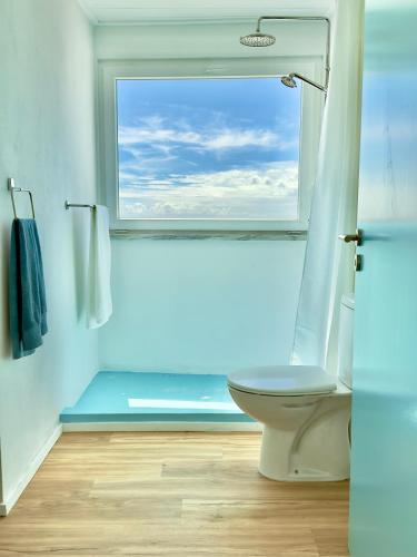 a bathroom with a toilet and a large window at Cliff House, Azores splendid Ocean View in Horta