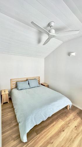 a bedroom with a bed with a ceiling fan at Cliff House, Azores splendid Ocean View in Horta