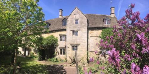 a large stone house with flowers in front of it at 6 Bedroom Farm House with 12 Beds in Weldon in Weldon