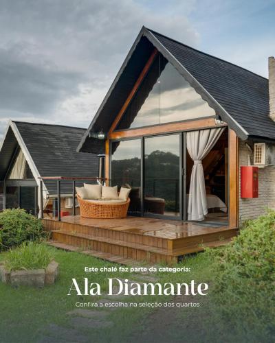 a house with a deck with a large glass window at Pousada das Pedras in Monte Verde