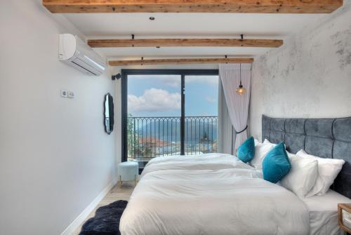 a bedroom with a large bed and a large window at Open Skys in Safed