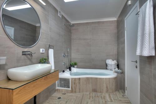 a bathroom with a tub and a sink and a mirror at Open Skys in Safed