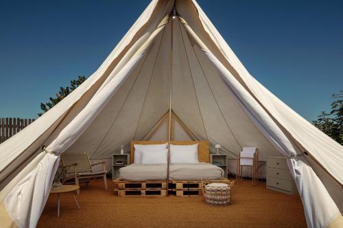 a tent with a bed and chairs in it at Glamping pospolu in Mokrovraty