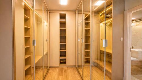 a walkin closet with glass doors and wood floors at Casa Premium no Centro - Passos do Alles Park in Pomerode