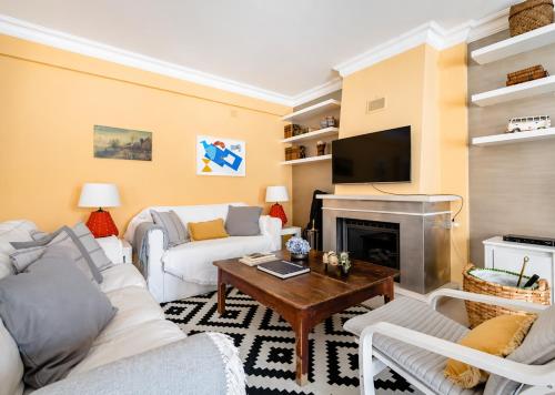 a living room with white furniture and a fireplace at Lisbon Coast, 3 bedroom apartment with large terrace in Linda-a-Velha