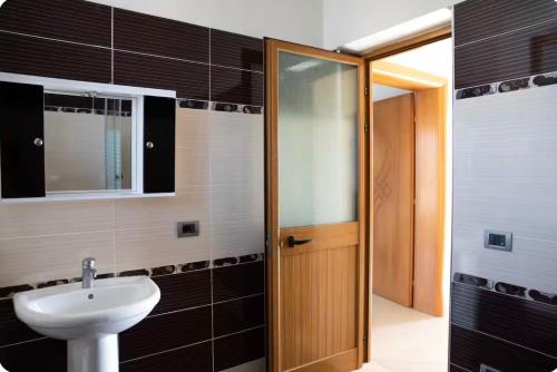 a bathroom with a sink and a glass door at Dreamy Heaven Escape Villa in Shijak