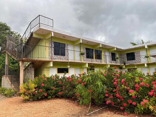 a yellow building with a balcony and some flowers at Hotel centro de Pedernales in Pedernales