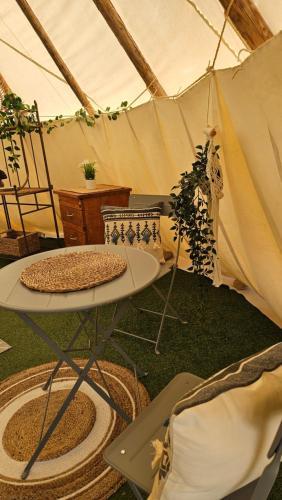 a tent with a table and a plant in it at Casa Bella Teepees in Zújar
