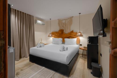 a bedroom with a large white bed and a television at M-Residence By Brassbell in Cairo