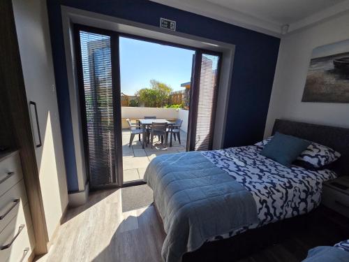 a bedroom with a bed and a balcony with a table at Seabreeze The Annexe in Blackpool