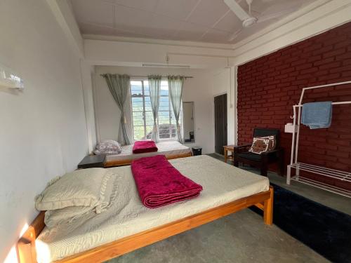 a bedroom with a bed with a red blanket on it at Saus Home in Khonoma