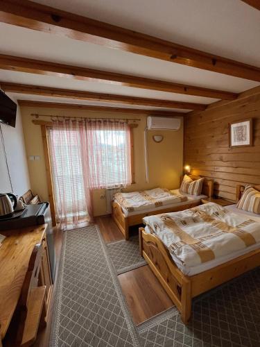 a large room with two beds and a television at Hotel Four Seasons in Samokov