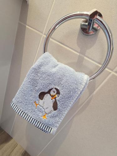 a towel with a penguin on it hanging on a rack at Seabreeze The Annexe in Blackpool