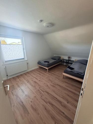 an empty room with two beds and a window at AlWi Apartment Wohnung 3 in Moringen