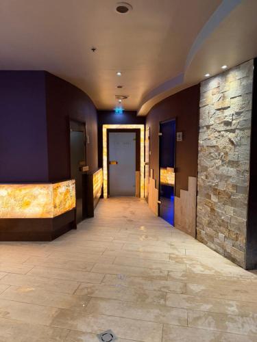 a hallway with a door and a stone wall at Tóth Wellness Apartman in Zalakaros