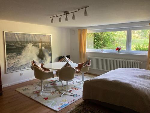 a bedroom with a bed and a table and chairs at Ferienhaus Heidelodge in Nebel