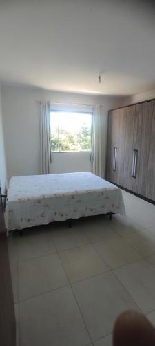 a bedroom with a large bed with a window at Casa de praia castelhanos in Anchieta