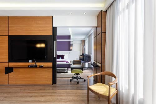 a hotel room with a bed and a desk with a television at Radisson Hotel Curitiba in Curitiba