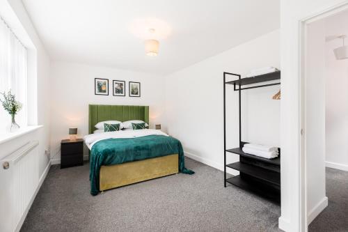 a bedroom with a bed with a green blanket at Birmingham Estate - Contractor & Group Accommodation - Secure Parking in Birmingham