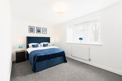 a bedroom with a blue bed and a window at Birmingham Estate - Contractor & Group Accommodation - Secure Parking in Birmingham