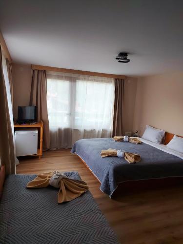two beds in a hotel room with towels on them at Villa Ribarica in Ribarica