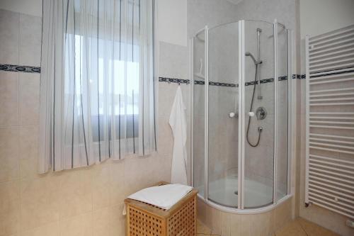 a bathroom with a shower with a toilet and a stool at Dünenschloss Wohnung 1-22 in Kühlungsborn