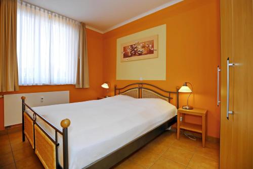 a bedroom with a large bed with orange walls at Dünenschloss Wohnung 1-34 in Kühlungsborn