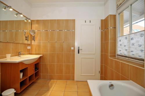 a bathroom with a tub and a sink at Dünenschloss Wohnung 1-34 in Kühlungsborn