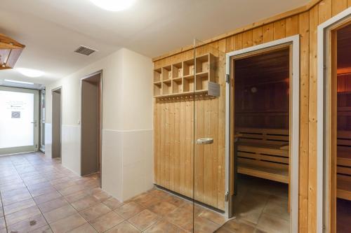a walk in closet with wooden walls and a glass door at Dünenschloss Wohnung 1-43 in Kühlungsborn