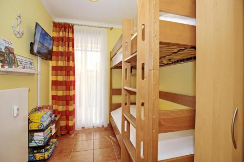 a small bedroom with bunk beds with a tv and a television at Dünenschloss Wohnung 4-03 in Kühlungsborn
