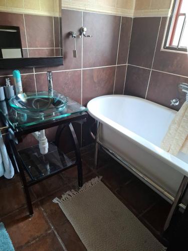 a bathroom with a bath tub and a sink at The Address Luxurious in Midrand