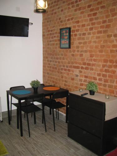 a room with two tables and chairs and a brick wall at Galega Guest House in Nazaré