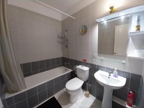 a bathroom with a white toilet and a sink at Comfortable and Ideally Situated in Paphos