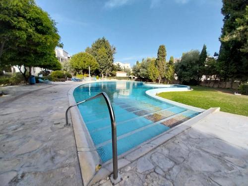 a swimming pool with a metal rail in a park at Comfortable and Ideally Situated in Paphos