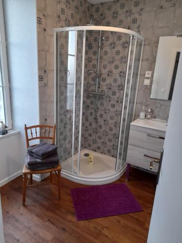 a shower in a bathroom with a chair and a sink at Chambres d'Hôtes et Table d'Hôtes- Valentine 44 in Sainte-Mère-Église