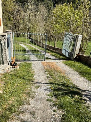 a gate on a dirt road next to a fence at Castori due in Prazzo