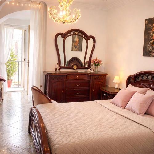 ein Schlafzimmer mit einem Bett, einer Kommode und einem Spiegel in der Unterkunft mistral'25 in Cefalú