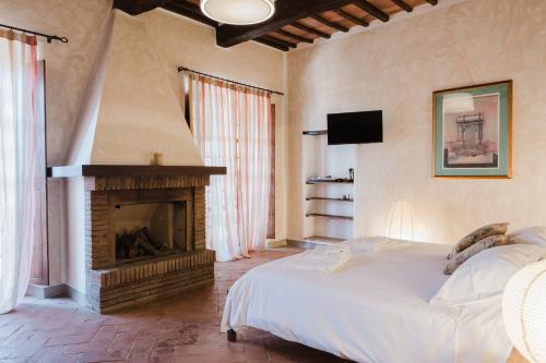 a bedroom with a bed and a fireplace at Tenuta Fattoria Vecchia in Scansano