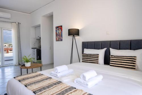 a bedroom with a large white bed with two towels at Studio Scirocco in Tympáki