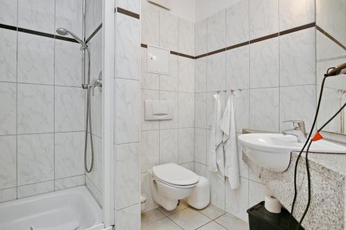 a bathroom with a shower toilet and a sink at Ostseewelle Wohnung 24 in Kühlungsborn