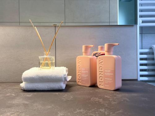 a group of three bottles of soap and a towel at René Apartments in Salsomaggiore Terme
