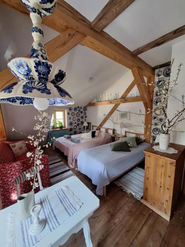 ein Schlafzimmer im Dachgeschoss mit zwei Betten und einem Kronleuchter in der Unterkunft Moniówka in Nowe Kawkowo