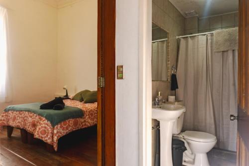 a bedroom with a bed and a sink and a toilet at Gatalegre Hostel in Valparaíso