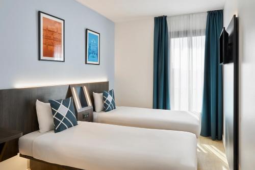 a hotel room with two beds and a window at Four Points Flex by Sheraton Madrid Atocha in Madrid