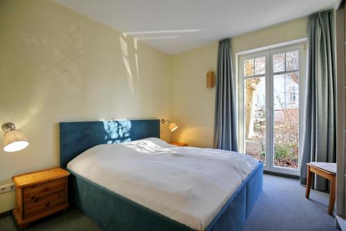a bedroom with a large bed and a window at Villa Seepferdchen Wohnung 01 in Kühlungsborn
