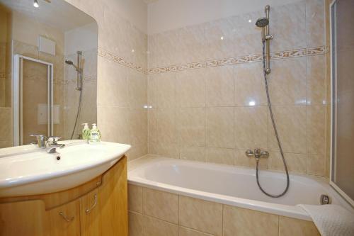 a bathroom with a tub and a sink and a shower at Villa Seepferdchen Wohnung 01 in Kühlungsborn
